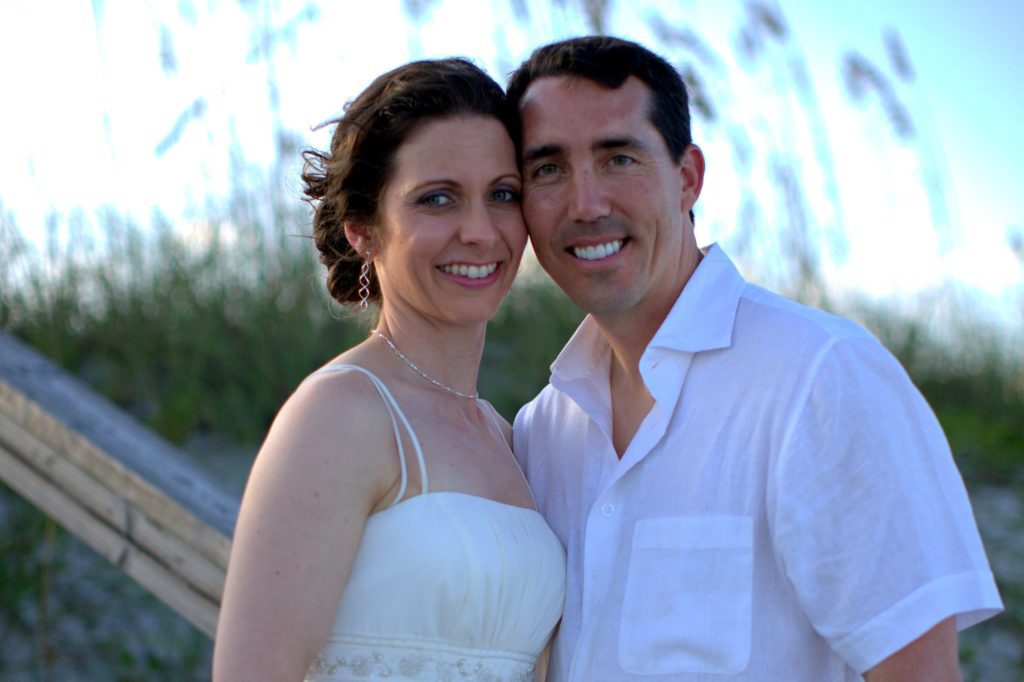 bride and groom smiling at the beach