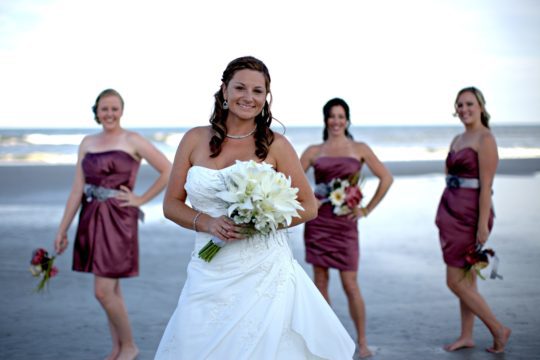 bride with bridesmaids on the beach