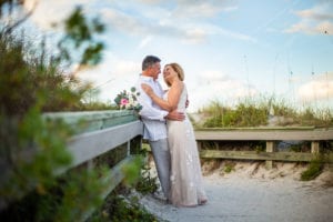 a recently married couple leaning against the railing at Amelia Island Beach, florida beach wedding, wedding planner amelia island