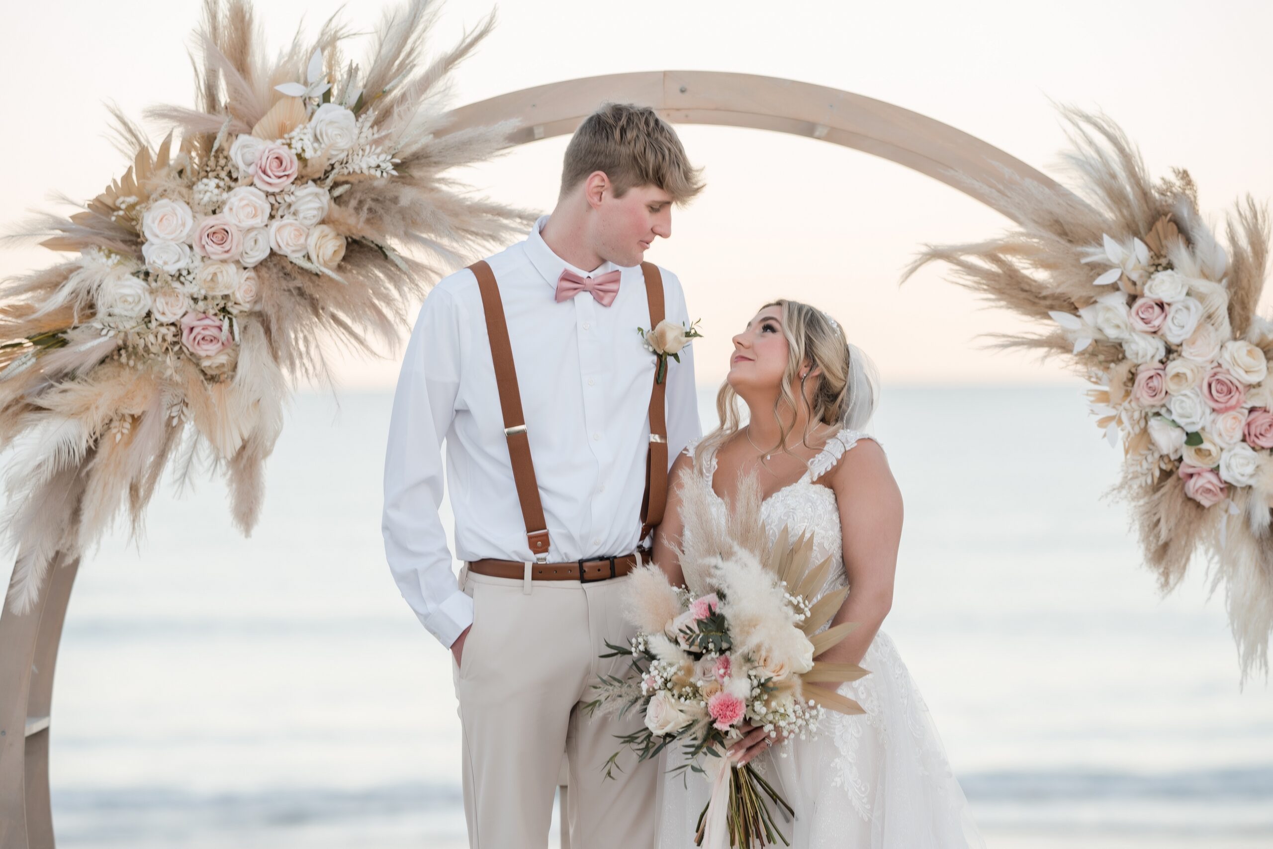 St. Augustine beach weddings - ceremony with circular arbor and white chairs at sunset
