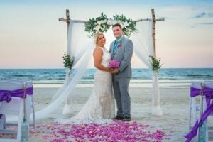 bride and groom under the arbor on jacksonville beach, best beach wedding venue, wedding planner