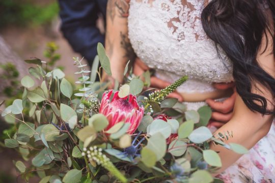 groom holding bride with bouquet