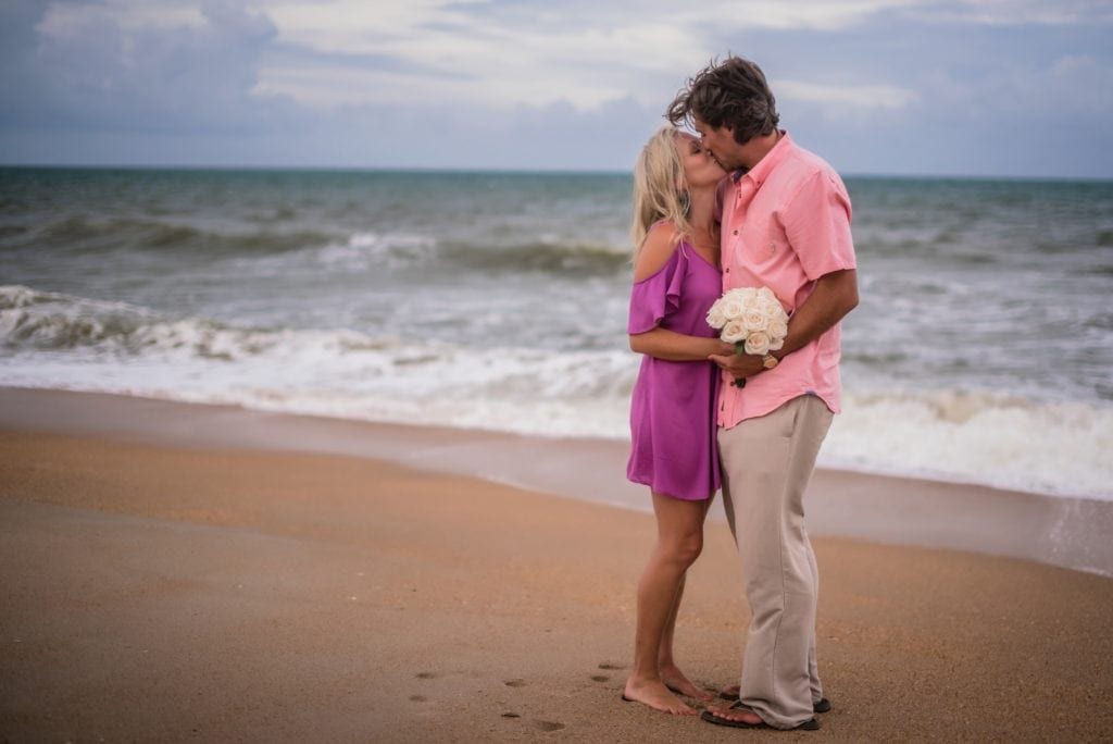 bride and groom kissing on beach