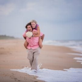 groom carrying bride on beach
