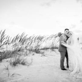 bride and groom in front of beach grass