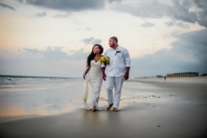 a recently married couple walking on Amelia Island Beach at sunset, florida wedding, wedding planner