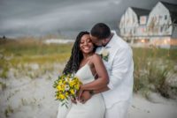 bride and groom in front of beach grass