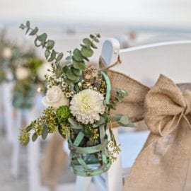 Gorgeous floral arrangements adorning aisle of beach wedding