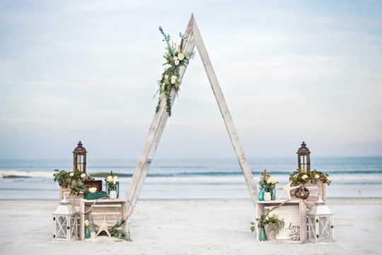 Wooden triangle arch included in decorative beach wedding package