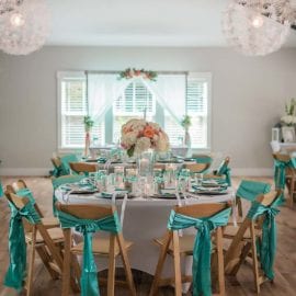 Wedding reception hall decorated with teal ribbons