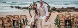 bride and groom in front of circular beach wedding arbor, beach wedding venue, beach wedding
