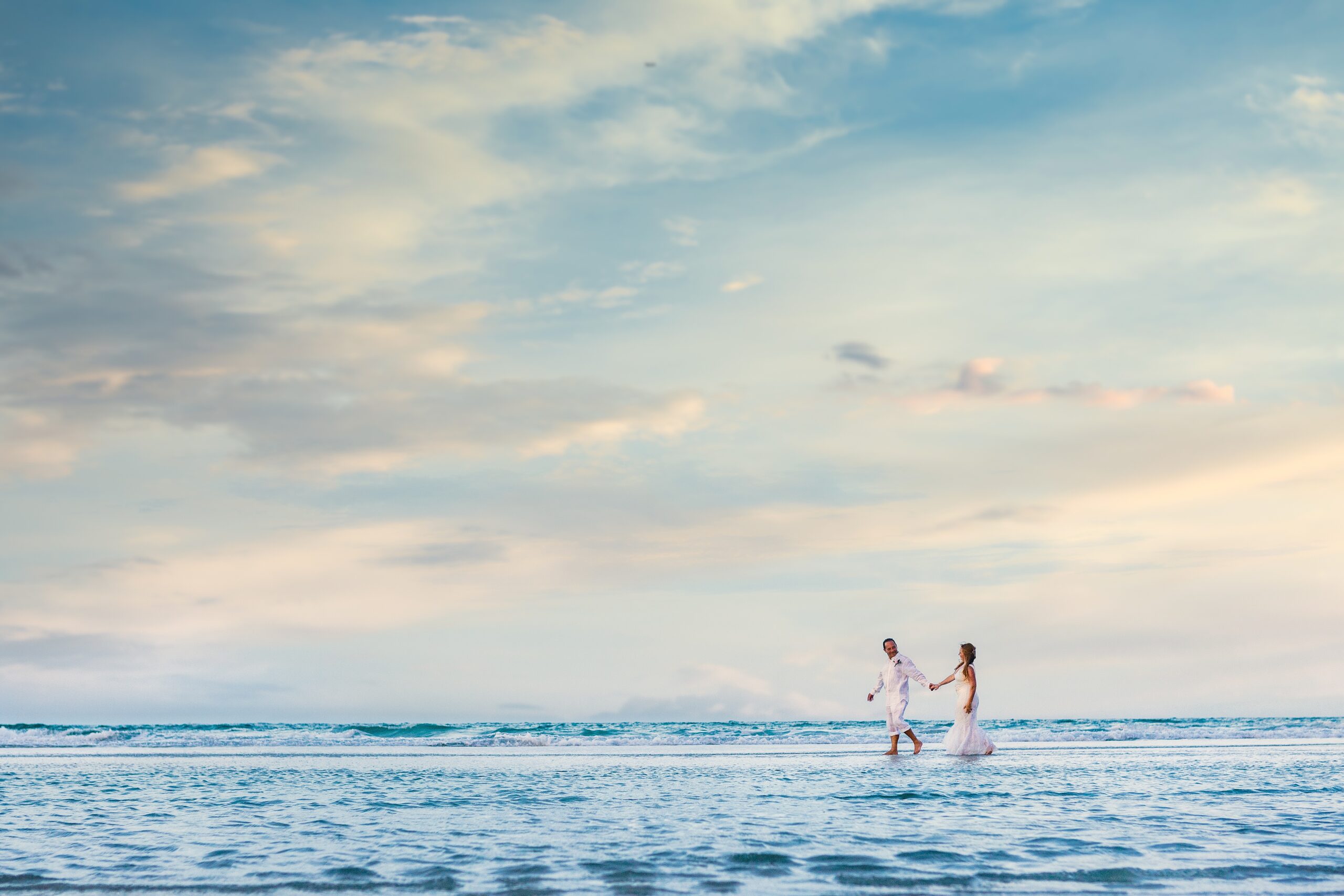 a bride and groom walking on a sandbeach in st augustine for a beach wedding ceremony, beach wedding, wedding after party