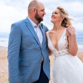 a bride and groom laughing and looking at each other while standing on the beach, beach wedding, beach wedding attire
