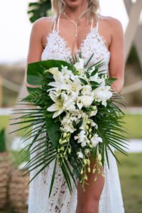 a bride holding a beautiful bouquet of flowers, affordable beach wedding, beach wedding florida