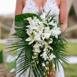 a bride holding a beautiful bouquet of flowers, Beach Bouquet ideas, beach wedding