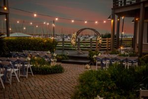 a boho arch with seating for guests and stringed lights above for a beach wedding ceremony, beach wedding, wedding after party