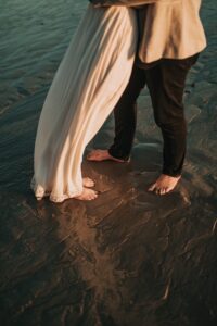 a groom and bride standing next to each other barefoot in the sand, florida beach wedding, beach wedding