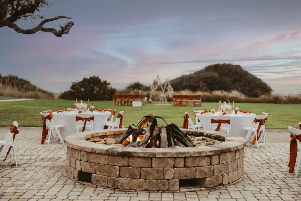 a fireplace set up in the middle of a wedding reception near the beach in florida, wedding videographer, beach wedding